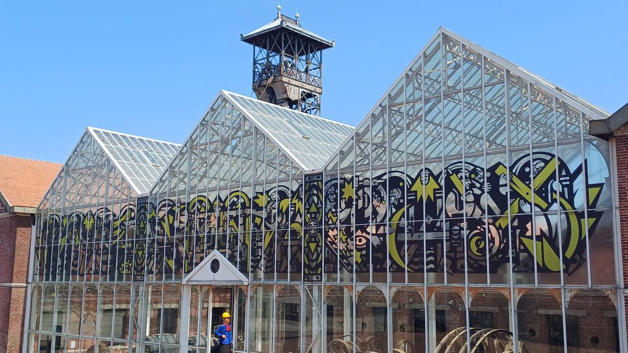 Black-and-yellow frieze on the historic glazed machine hall, Lewarde